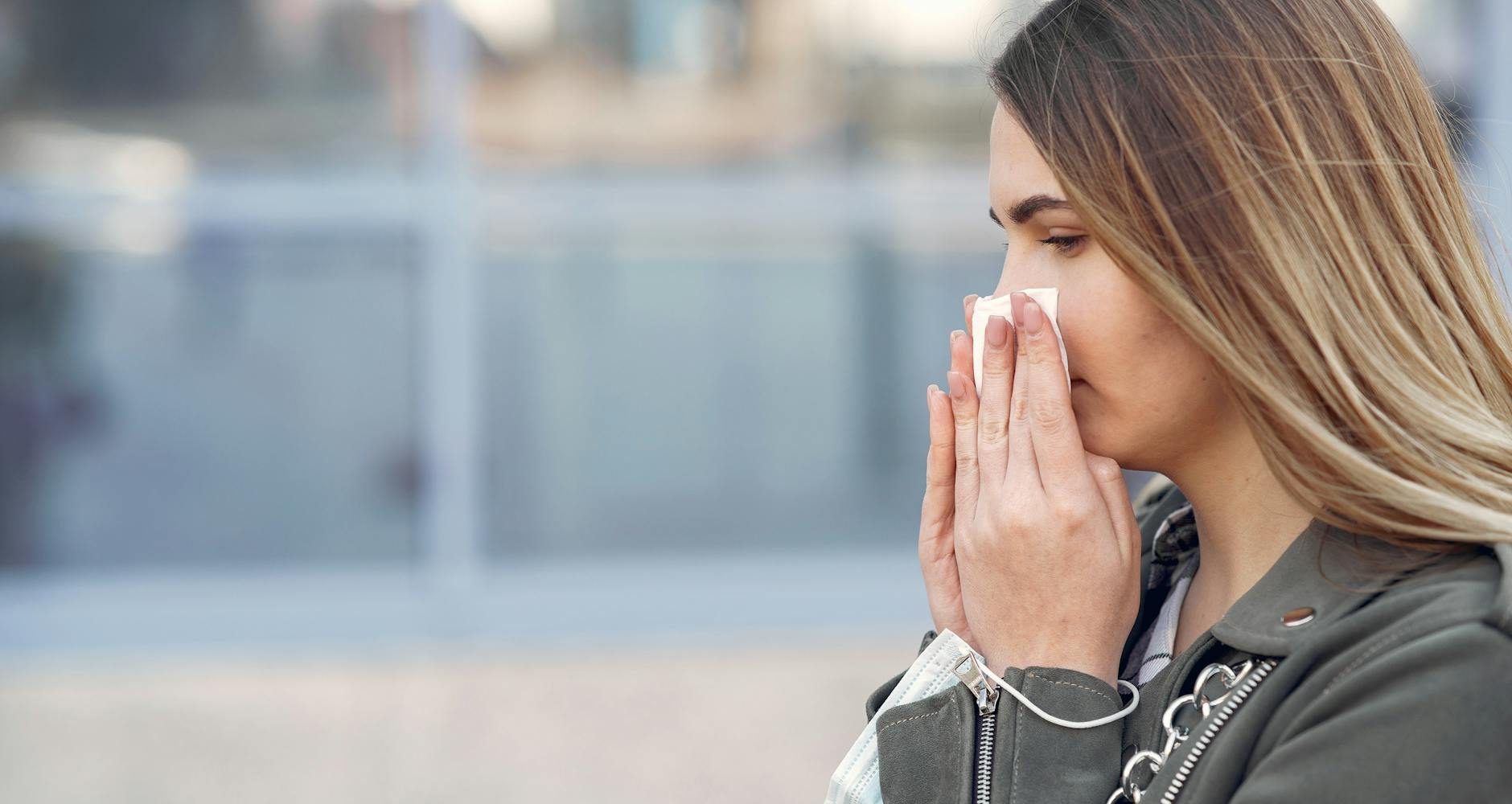 woman wiping her nose with tissue